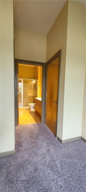 corridor featuring carpet floors and baseboards