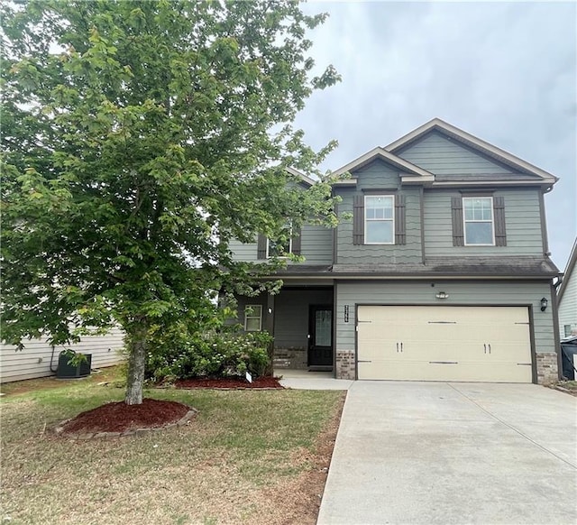craftsman house with a garage, concrete driveway, and a front lawn