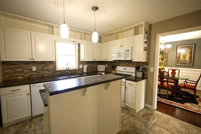 kitchen featuring white cabinetry, sink, a textured ceiling, white appliances, and a kitchen island