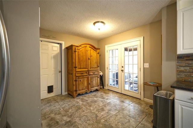 entryway featuring french doors and a textured ceiling