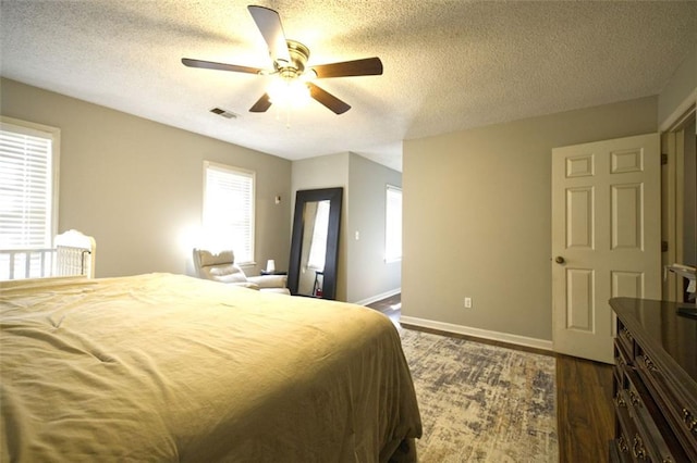 bedroom featuring a textured ceiling, dark hardwood / wood-style floors, and ceiling fan