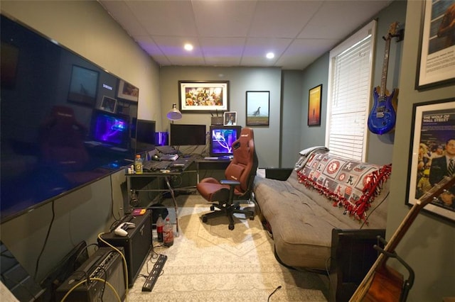 carpeted home office with a paneled ceiling