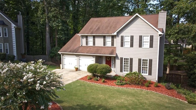 colonial-style house featuring a front yard and a garage