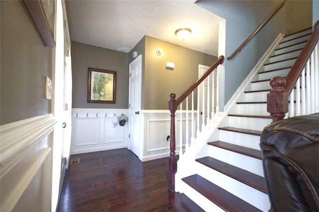 foyer featuring a textured ceiling and dark hardwood / wood-style flooring