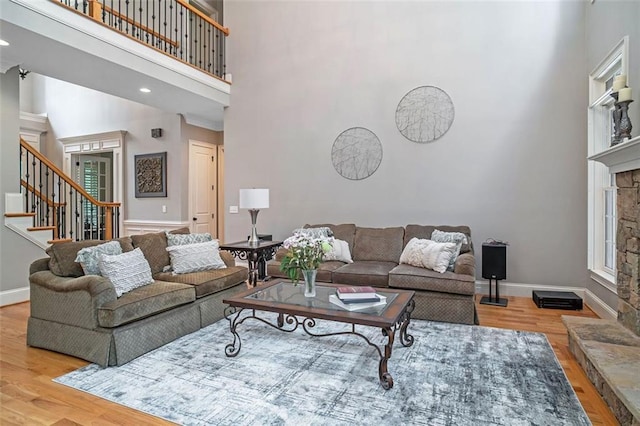 living room featuring a high ceiling, light hardwood / wood-style flooring, and a fireplace