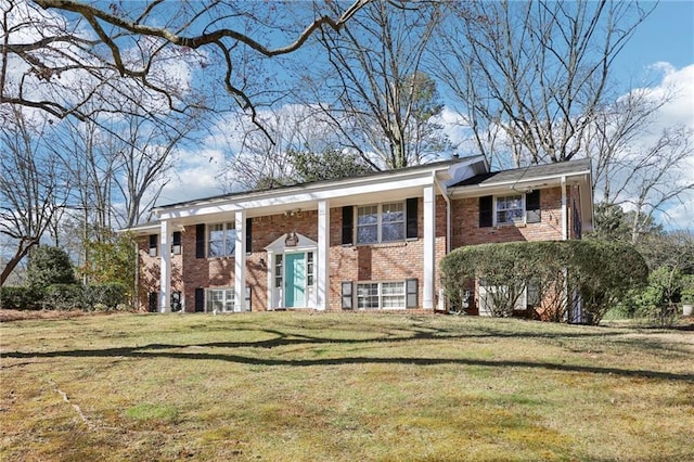 split foyer home featuring brick siding and a front yard