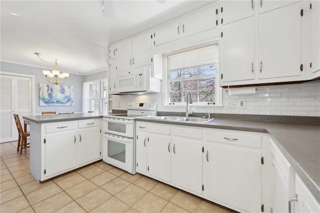 kitchen with white appliances, white cabinets, a peninsula, a sink, and backsplash