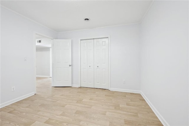 unfurnished bedroom featuring light wood-style flooring, ornamental molding, and baseboards