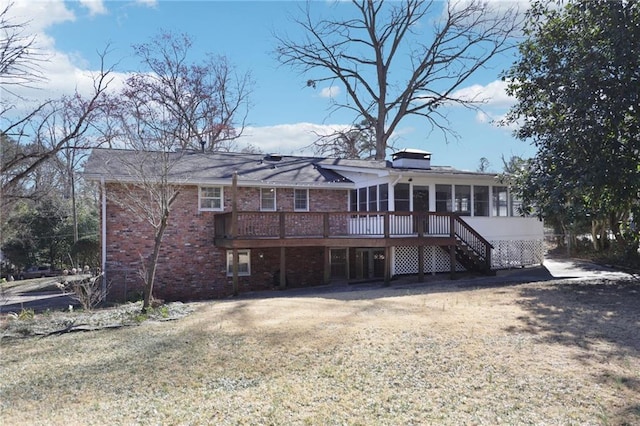 back of house with stairway, a sunroom, brick siding, and a deck