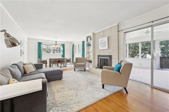 living area featuring a brick fireplace, crown molding, and wood finished floors