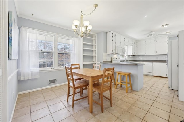 dining room with light tile patterned floors, baseboards, visible vents, and ceiling fan with notable chandelier