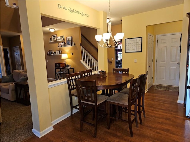 dining room with dark wood-type flooring and an inviting chandelier