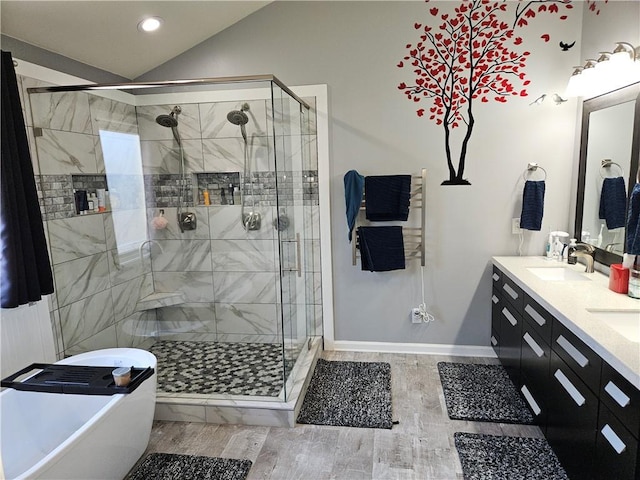 bathroom featuring vanity, plus walk in shower, vaulted ceiling, and wood-type flooring