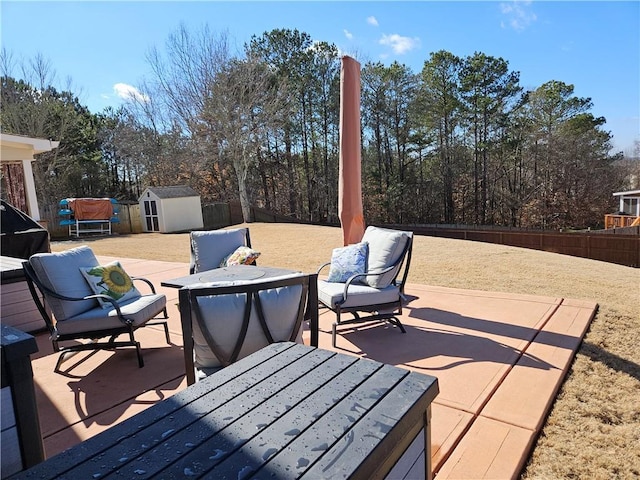 wooden deck featuring a shed, an outdoor hangout area, and a patio area