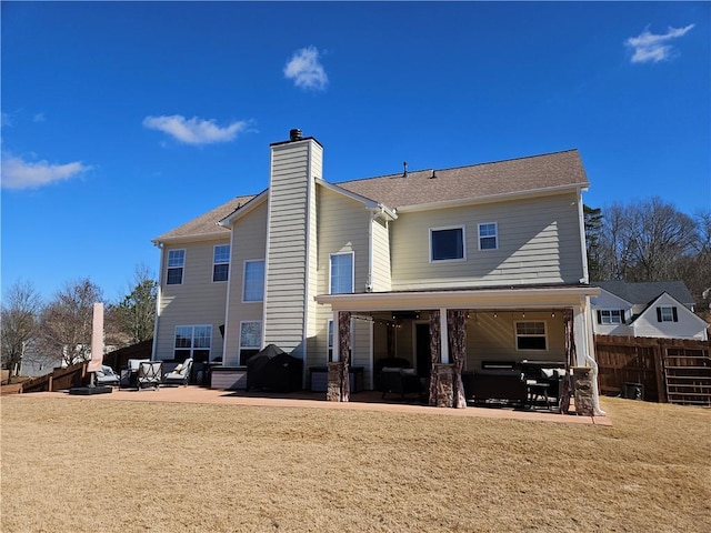 rear view of property featuring a patio and a lawn