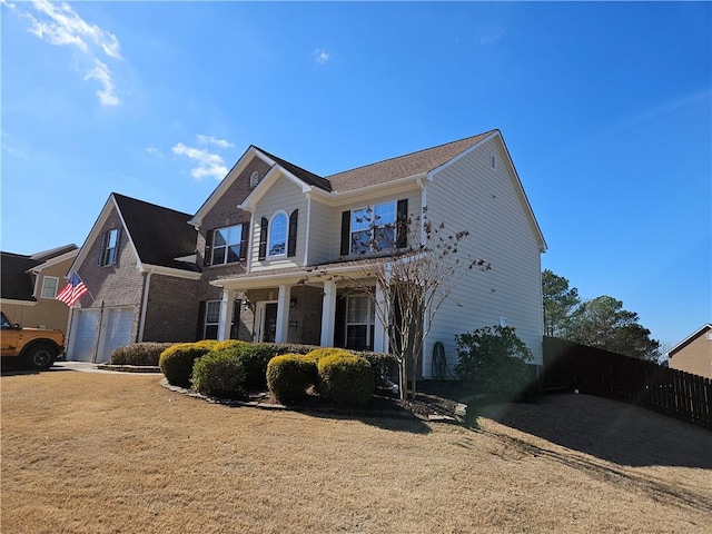 view of front of home featuring a garage, covered porch, and a front lawn