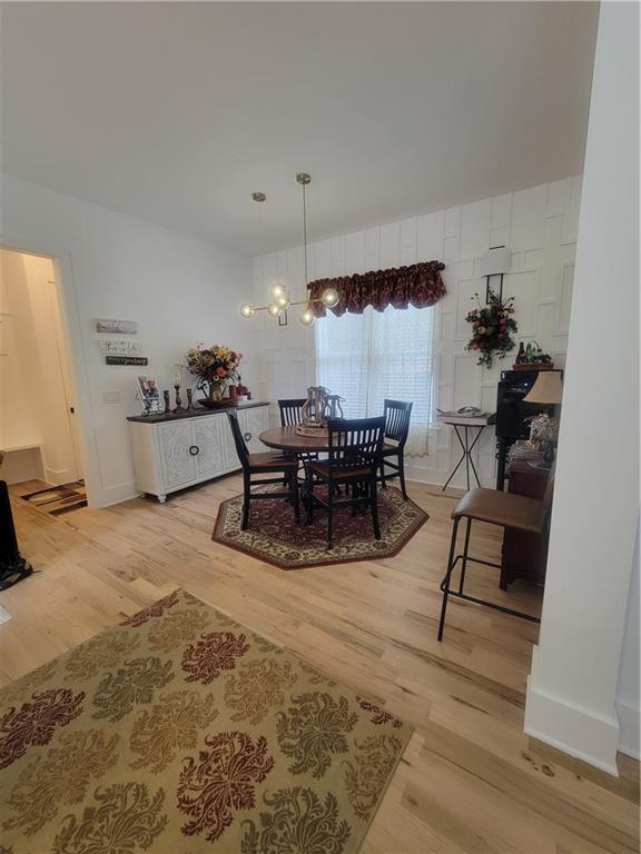 dining area featuring a notable chandelier and light wood-type flooring