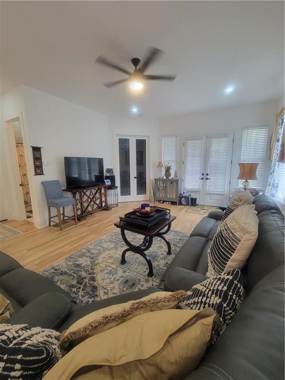 living room with french doors, ceiling fan, and wood-type flooring