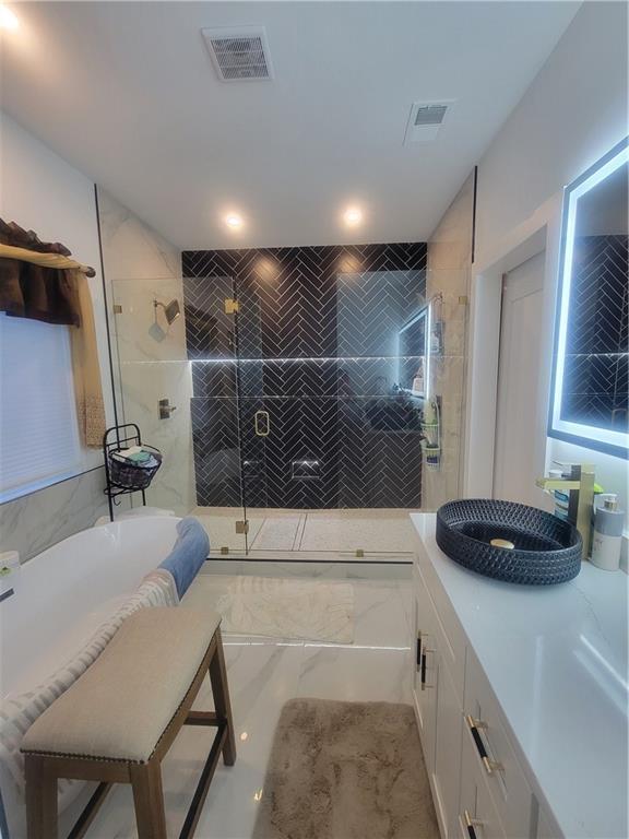 bathroom featuring vanity and separate shower and tub