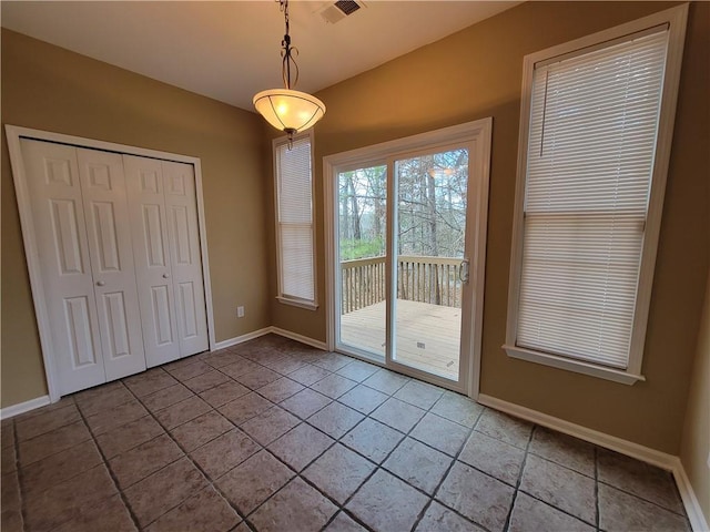unfurnished dining area with tile patterned flooring and baseboards