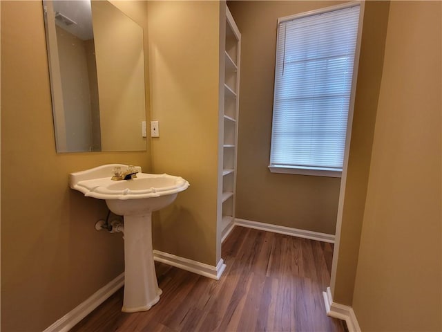 bathroom with wood finished floors and baseboards