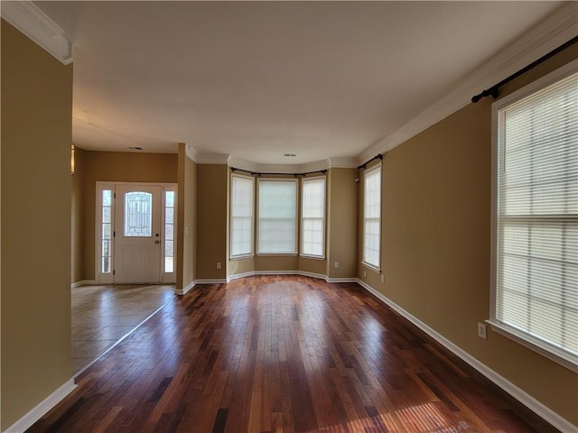 foyer featuring dark wood-type flooring, baseboards, and crown molding