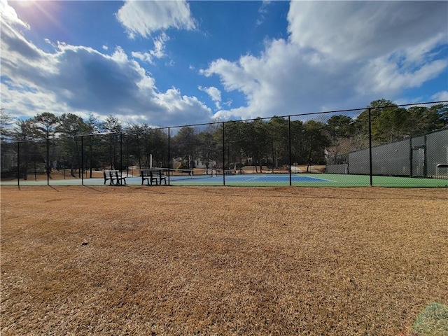 view of property's community with fence and a tennis court