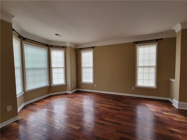spare room featuring dark wood-style flooring, baseboards, and ornamental molding