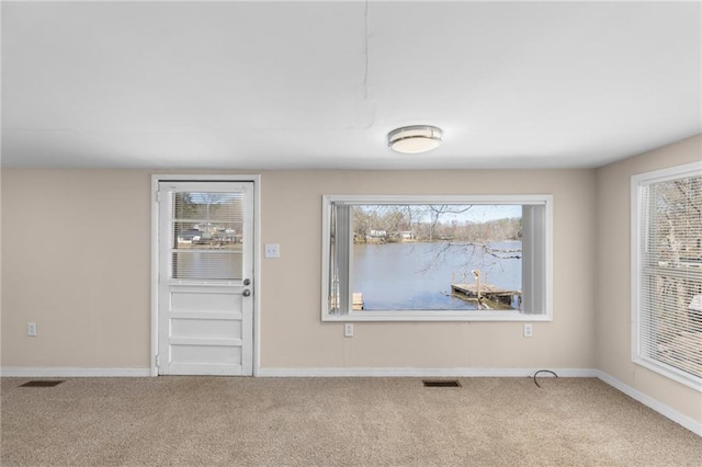 carpeted foyer featuring baseboards and visible vents