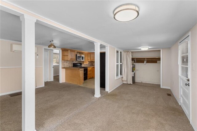 carpeted empty room with baseboards and decorative columns
