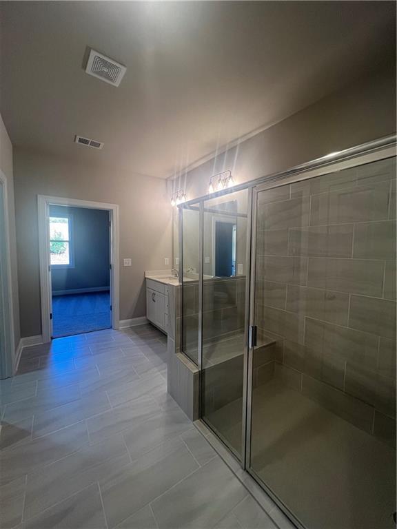 bathroom with vanity, tile patterned flooring, and a shower with door