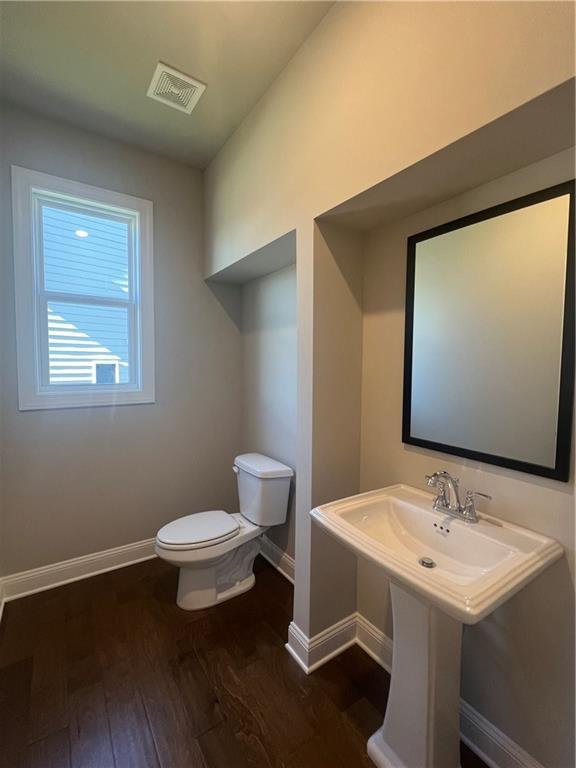 bathroom with hardwood / wood-style flooring and toilet