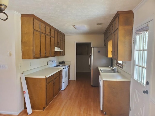 kitchen featuring white electric stove, visible vents, light countertops, under cabinet range hood, and a sink