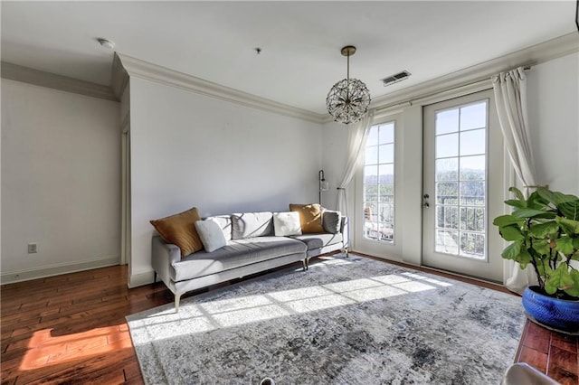 living room featuring a healthy amount of sunlight, dark hardwood / wood-style flooring, and a notable chandelier