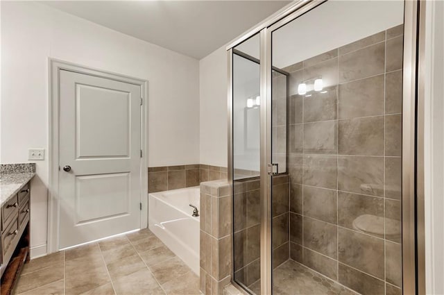 bathroom featuring tile patterned flooring, vanity, and plus walk in shower