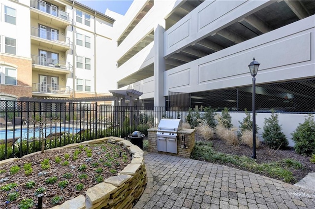 view of patio / terrace with area for grilling and a community pool