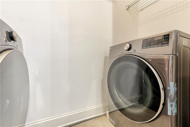 laundry room featuring light tile patterned floors and washer / dryer