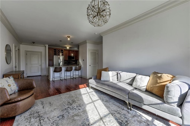 living room featuring dark wood-type flooring, crown molding, and a chandelier