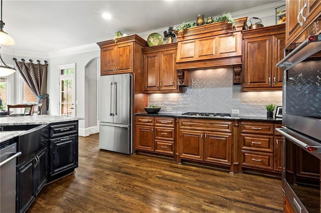 31 Brownson Ct, Acworth, GA 30101 - kitchen featuring crown molding, decorative backsplash, arched walkways, dark wood finished floors, and appliances with stainless steel finishes