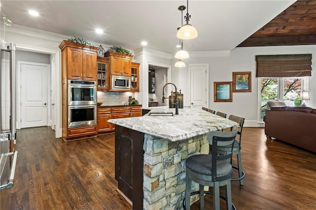 31 Brownson Ct, Acworth, GA 30101 - kitchen with brown cabinets, appliances with stainless steel finishes, a breakfast bar, light stone counters, and dark wood finished floors