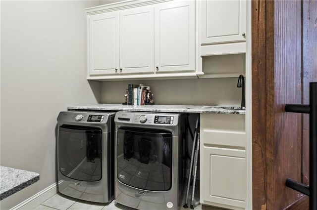 31 Brownson Ct, Acworth, GA 30101 - laundry area with cabinet space, light tile patterned flooring, baseboards, and washing machine and dryer