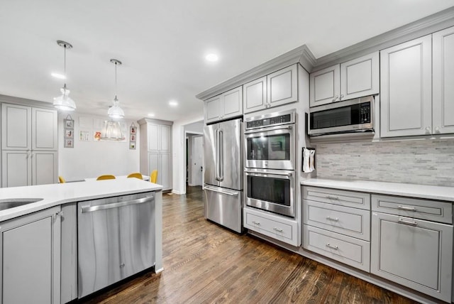 1315 Merry Ln NE, Atlanta, GA 30329 - kitchen featuring appliances with stainless steel finishes, gray cabinetry, light countertops, dark wood-style floors, and tasteful backsplash