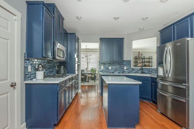 2075 Old Georgian Ter NW, Atlanta, GA 30318 - kitchen featuring stainless steel appliances, blue cabinets, a center island, a sink, and light countertops