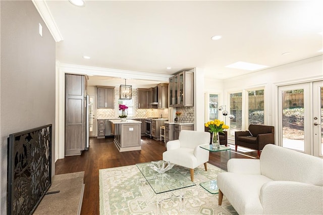 living area featuring french doors, ornamental molding, dark wood-type flooring, and recessed lighting