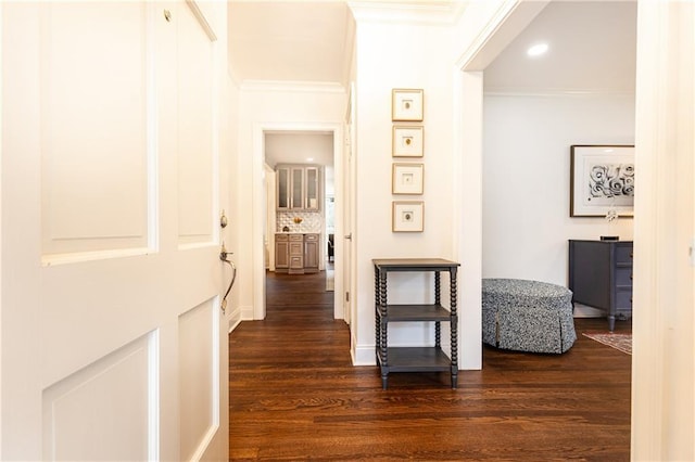 corridor with baseboards, dark wood-type flooring, crown molding, and recessed lighting