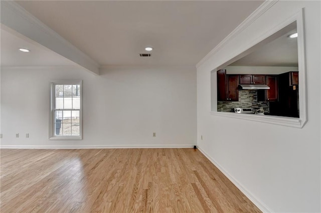 spare room featuring beam ceiling, crown molding, and light wood-type flooring