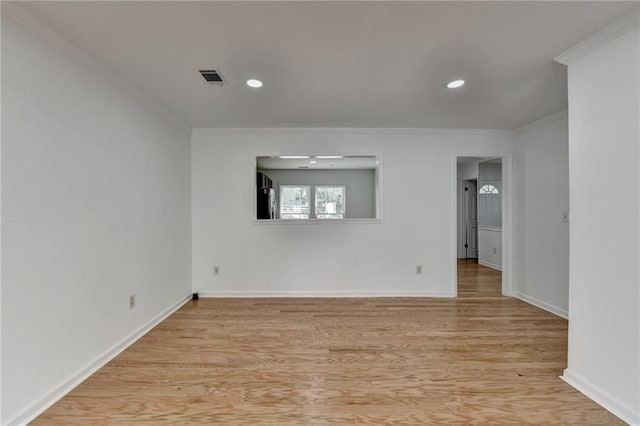 unfurnished room featuring crown molding and light hardwood / wood-style floors