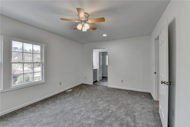 unfurnished bedroom with carpet floors, connected bathroom, and ceiling fan