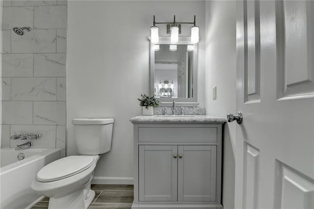 full bathroom with hardwood / wood-style flooring, vanity, toilet, and tiled shower / bath