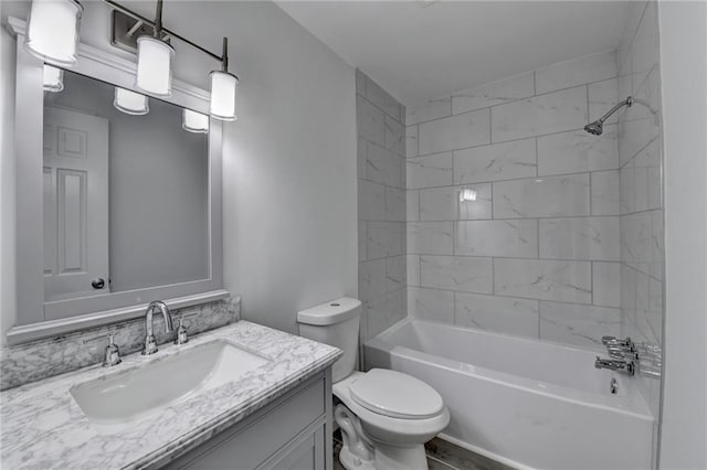 full bathroom with tiled shower / bath, vanity, and toilet